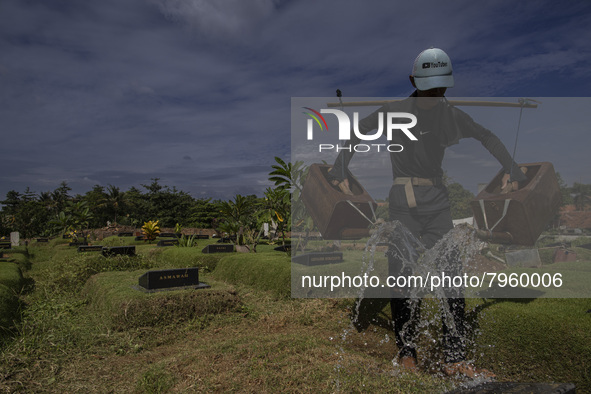 Officers clean the COVID-19 graveyard in Srengsesngsawah, South Jakata, Jakarta, Indonesia. Towards Ramadan, officers clean the graves, so t...