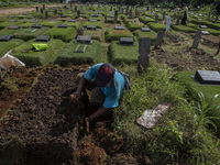 Officers clean the COVID-19 graveyard in Srengsesngsawah, South Jakata, Jakarta, Indonesia. Towards Ramadan, officers clean the graves, so t...