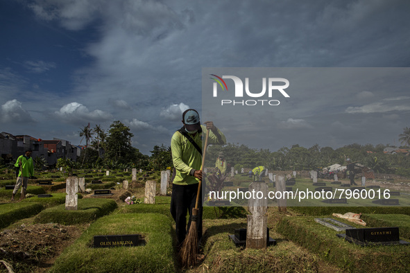 Officers clean the COVID-19 graveyard in Srengsesngsawah, South Jakata, Jakarta, Indonesia. Towards Ramadan, officers clean the graves, so t...