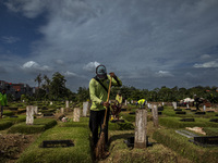 Officers clean the COVID-19 graveyard in Srengsesngsawah, South Jakata, Jakarta, Indonesia. Towards Ramadan, officers clean the graves, so t...