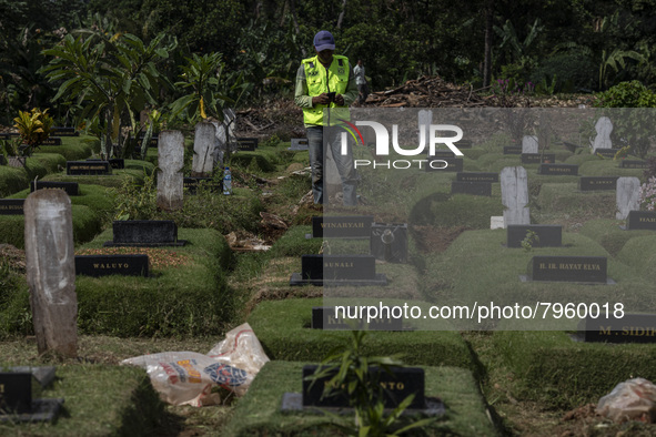 Officers clean the COVID-19 graveyard in Srengsesngsawah, South Jakata, Jakarta, Indonesia. Towards Ramadan, officers clean the graves, so t...