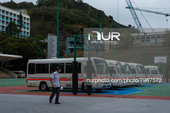 A driver looks at the ambulance buses which are parked on a basket ball terrain near the United Christian Hospital in Kwun Tong, in Hong Kon...