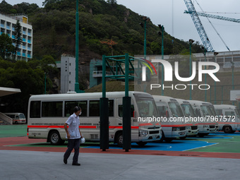 A driver looks at the ambulance buses which are parked on a basket ball terrain near the United Christian Hospital in Kwun Tong, in Hong Kon...