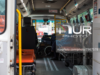 A paramedic checks his phone while waiting in an ambulance bus to transfer patients at United Christian Hospital, in Kwun Tong, in Hong Kong...