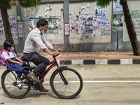 Father taking his child to school on a bicycle in Dhaka, Bangladesh on 27th March, 2022. (