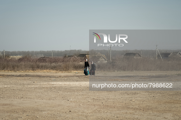 Ukrainian citizens are seen arriving by foot at the transit point for refugees in Palanca, south Moldova, on 2022-03-27. 