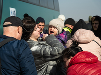 An Ukrainian child is seen crying in her mother's arms, among many other Ukrainian citizens at the transit point for refugees in Palanca, so...