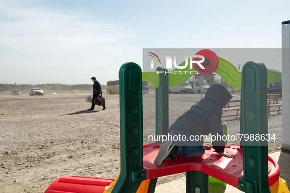 Ukrainian child is seen play while a man ig going to get the bus, at the transit point for refugees in Palanca, south Moldova, on 2022-03-27...