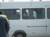 Ukrainian citizens are seen through the screens of a mini bus, at the transit point for refugees in Palanca, south Moldova, on 2022-03-27. (