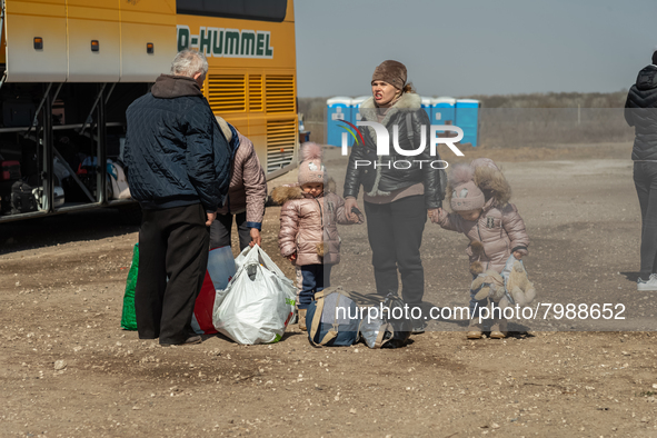 An Ukrainian family of five is seen fighting agains the strong wind at the transit point for refugees in Palanca, south Moldova, on 2022-03-...