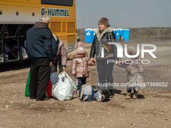 An Ukrainian family of five is seen fighting agains the strong wind at the transit point for refugees in Palanca, south Moldova, on 2022-03-...