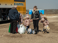 An Ukrainian family of five is seen fighting agains the strong wind at the transit point for refugees in Palanca, south Moldova, on 2022-03-...