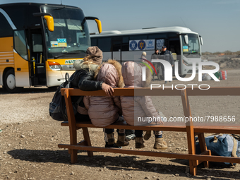 An Ukrainian mother and her two twin daughters is seen waiting for the bus at the transit point for refugees in Palanca, south Moldova, on 2...