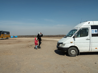 An Ukrainian mother and daughter are seen fighting agains the strong wind at the transit point for refugees in Palanca, south Moldova, on 20...