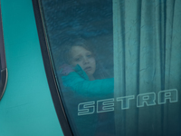 An Ukrainian girl is seen through the screen of a bus headed to Bucarest, Romania, at the transit point for refugees in Palanca, south Moldo...