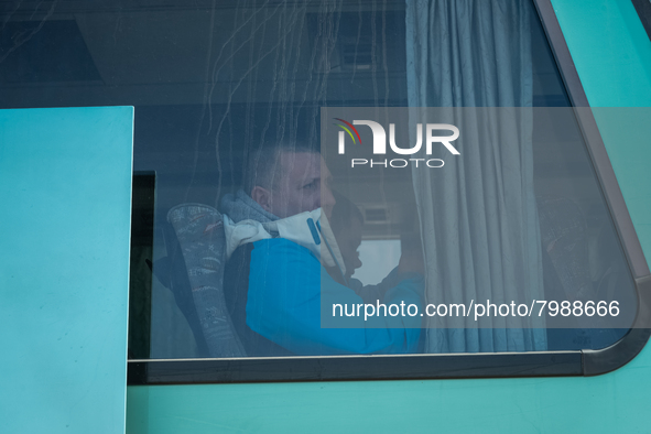 Ukrainian citizens are seen through the screen of a bus headed to Bucarest, Romania, at the transit point for refugees in Palanca, south Mol...