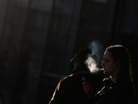 A woman smokes a cigarette using a tobacco heater
 in Krakow, Poland on March 28, 2022. (