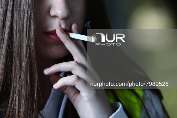 A woman smokes a cigarette in Krakow, Poland on March 28, 2022. 