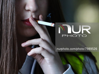 A woman smokes a cigarette in Krakow, Poland on March 28, 2022. (