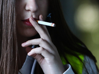 A woman smokes a cigarette in Krakow, Poland on March 28, 2022. (