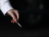 A woman smokes a cigarette in Krakow, Poland on March 28, 2022. (