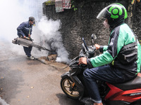 Health officials in the field of public environment carry out fumigation of the environment on residents in Grinding, Jakarta on March 29, 2...