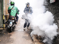 Health officials in the field of public environment carry out fumigation of the environment on residents in Grinding, Jakarta on March 29, 2...