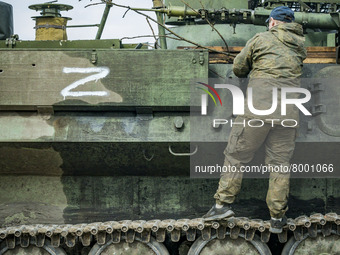 Ukrainian soldier in a captured armored vehicle with the symbol Z of the russian army in Kharkiv, Ukraine. (