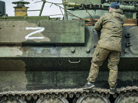 Ukrainian soldier in a captured armored vehicle with the symbol Z of the russian army in Kharkiv, Ukraine. (
