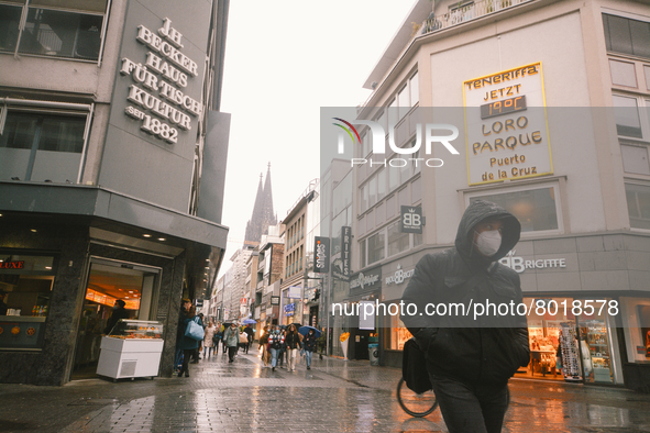 a shopper walks with face mask in the city center of Cologne, Germany on April 4, 2022 after Germany lifts majority of covid 19 restrictions...