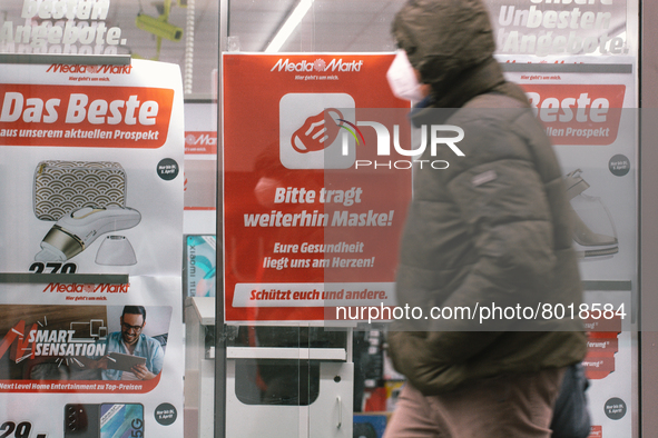 "please keept wearing face mask" sign is seen hanging in front of Media markt, the electronic restailer  in the city center of Cologne, Germ...