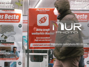 "please keept wearing face mask" sign is seen hanging in front of Media markt, the electronic restailer  in the city center of Cologne, Germ...