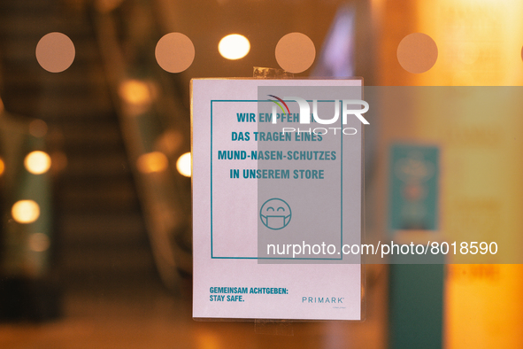 "we recommend to wear face mask in our store" sign is seen in front of Primark, the clothing restailer in the city center of Cologne, German...