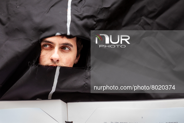 A student wearing a giant Biden costume peers out from the opening during at a rally to cancel student debt at the Department of Education....