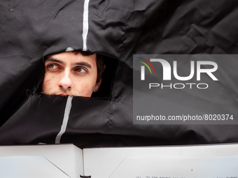 A student wearing a giant Biden costume peers out from the opening during at a rally to cancel student debt at the Department of Education....