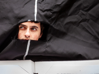 A student wearing a giant Biden costume peers out from the opening during at a rally to cancel student debt at the Department of Education....