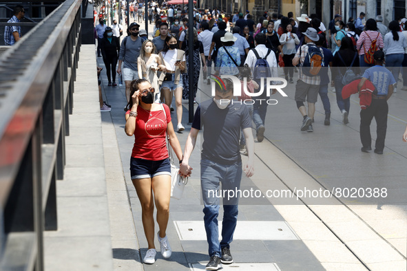 People take to the streets of the Mexico City downtown without wearing face masks, after the Government softened the measures due to the epi...