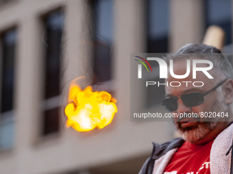 A 50-year-old man with debt as a result of going to college later in life, sets fire to a small piece of paper symbolizing his student debt...