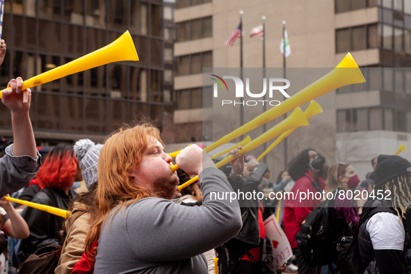 Protesters at a rally to cancel student debt blow yellow horns at the Department of Education.  Students took part in a day of action urging...