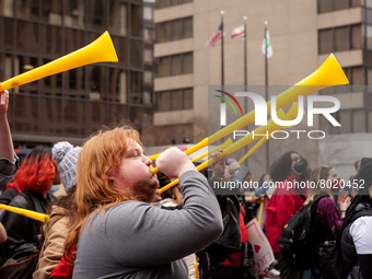 Protesters at a rally to cancel student debt blow yellow horns at the Department of Education.  Students took part in a day of action urging...