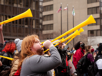 Protesters at a rally to cancel student debt blow yellow horns at the Department of Education.  Students took part in a day of action urging...