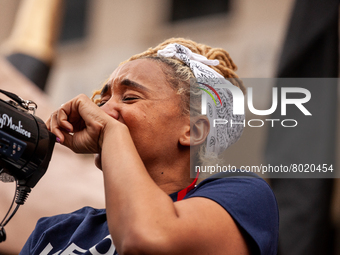 A protester chokes up while speaking about the harmful effects student debt has had on her life during a rally to cancel educational debt at...