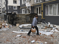 A woman goes near a damaged residential building in the recaptured by the Ukrainian army Bucha city near Kyiv, Ukraine, 04 April 2022. (