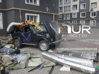 Destroyed civil vehicles  near a damaged residential building in the recaptured by the Ukrainian army Bucha city near Kyiv, Ukraine, 04 Apri...