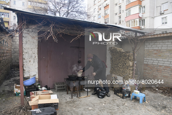 A woman is preparing a meal on fire next to apartments blocks in the recaptured by the Ukrainian army Bucha city near Kyiv, Ukraine, 04 Apri...