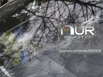 Ukrainian flag and Bullet holes on a screen of shelled civil car in the recaptured by the Ukrainian army Bucha city near Kyiv, Ukraine, 04 A...