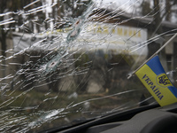 Ukrainian flag and Bullet holes on a screen of shelled civil car in the recaptured by the Ukrainian army Bucha city near Kyiv, Ukraine, 04 A...