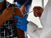 A health system personnel applies a dose of anti-Covid-19 vaccine to a child in the La Parada sector, near the city of Cucuta on the Colombi...