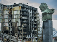Taras Shevchenko bust in the city of Borodianka, with a shelled building in the background destroyed during the combats between the russian...