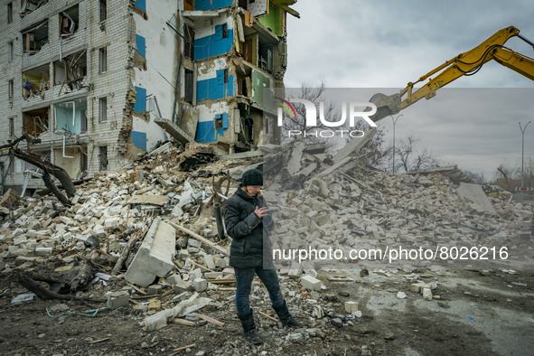 A woman checks in her phone the list of belongings recovered in the debris of her flat destroyed in the combats between the ukrainian and ru...